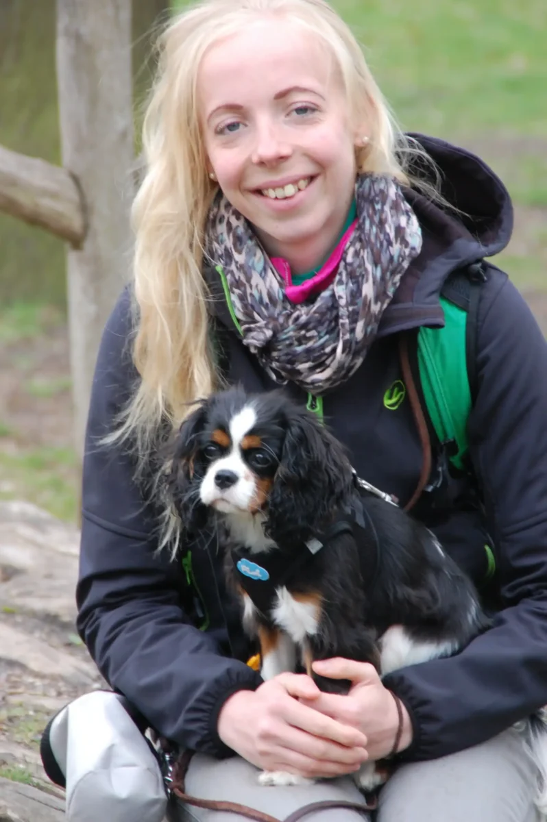 Eine junge blonde Frau mit einem Hund.