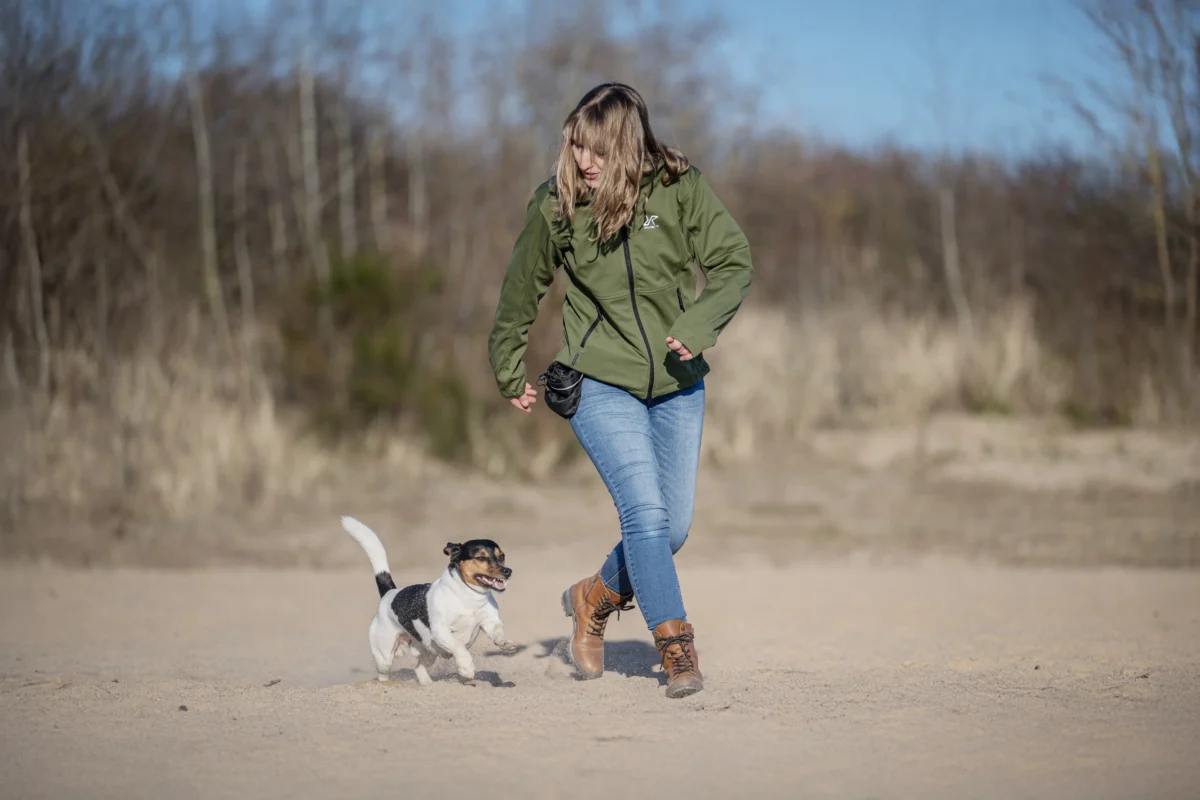Gemeinsam spielen Hund und Frauchen am See