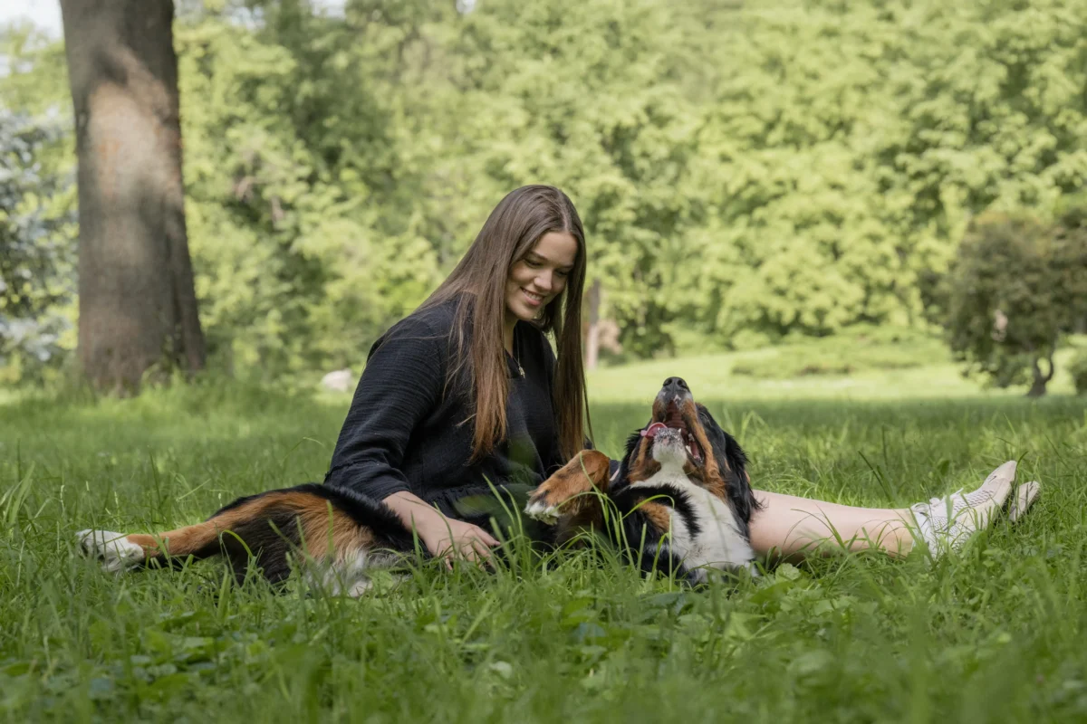 Ein großer Hund mit einem Mädchen auf der Wiese beim Kuscheln