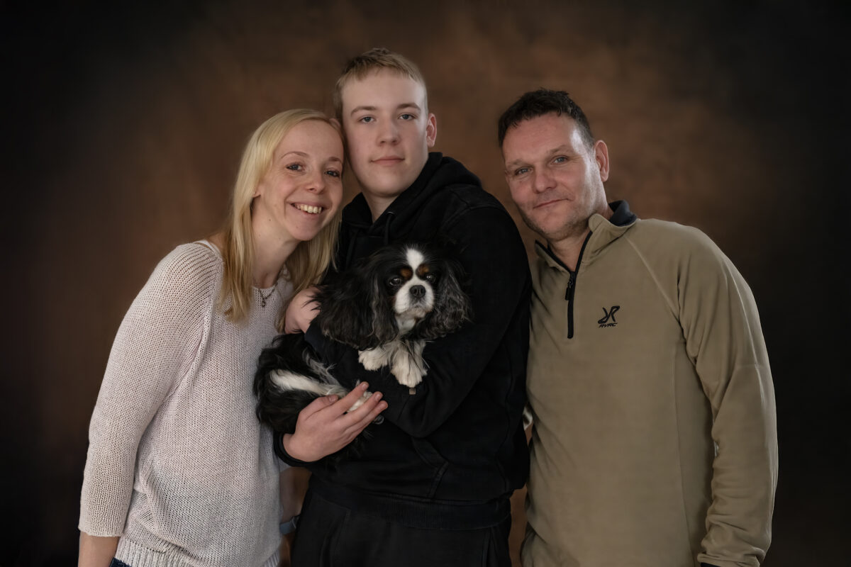 Eine Familie mit einem kleinen Hund auf dem Arm.