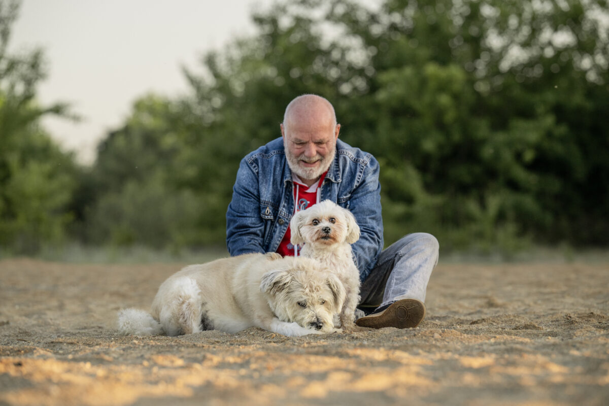 Ein Mann mit zwei Hunden am See