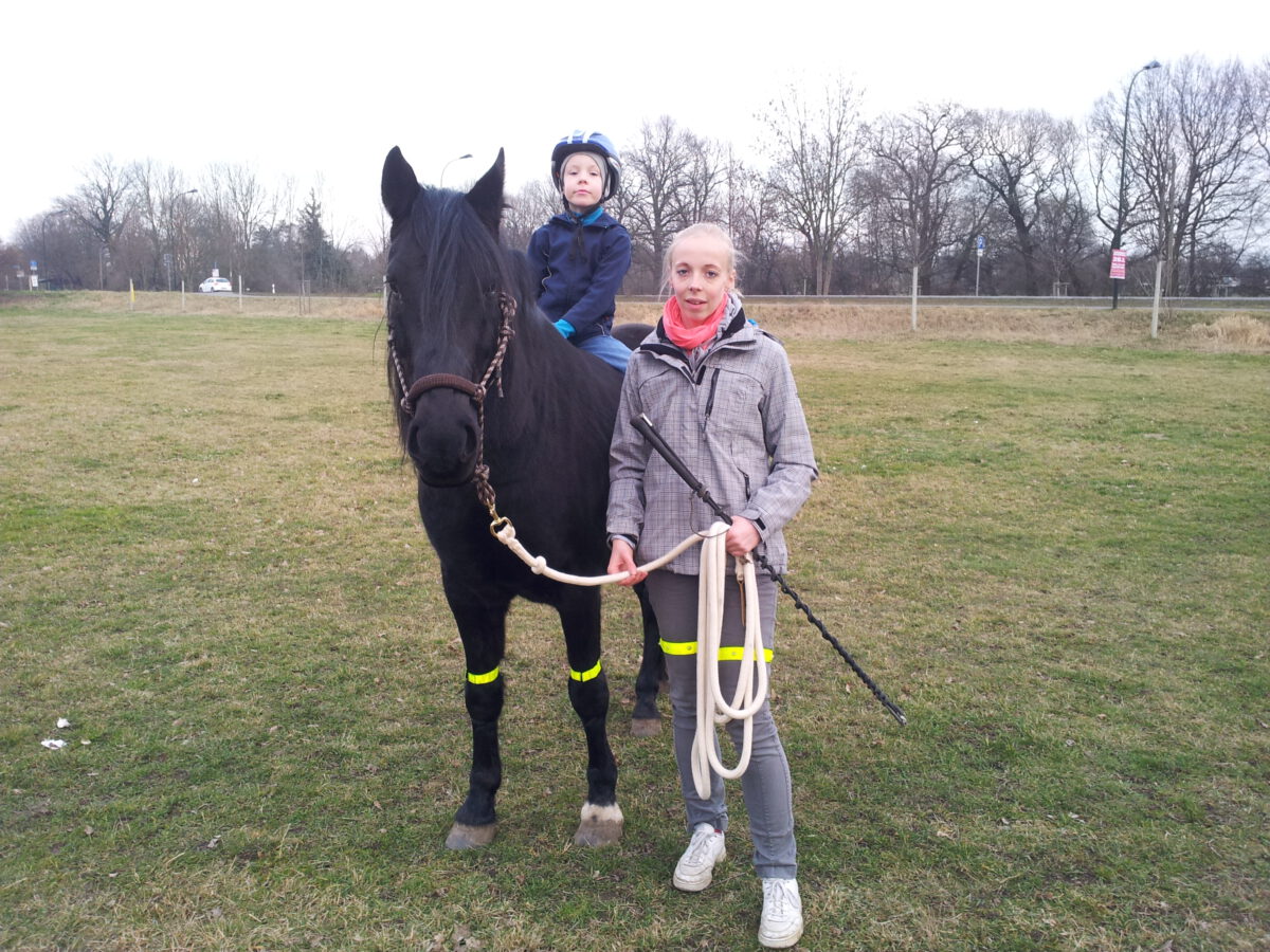 Ein kleiner junge auf einem schwarzem Pferd