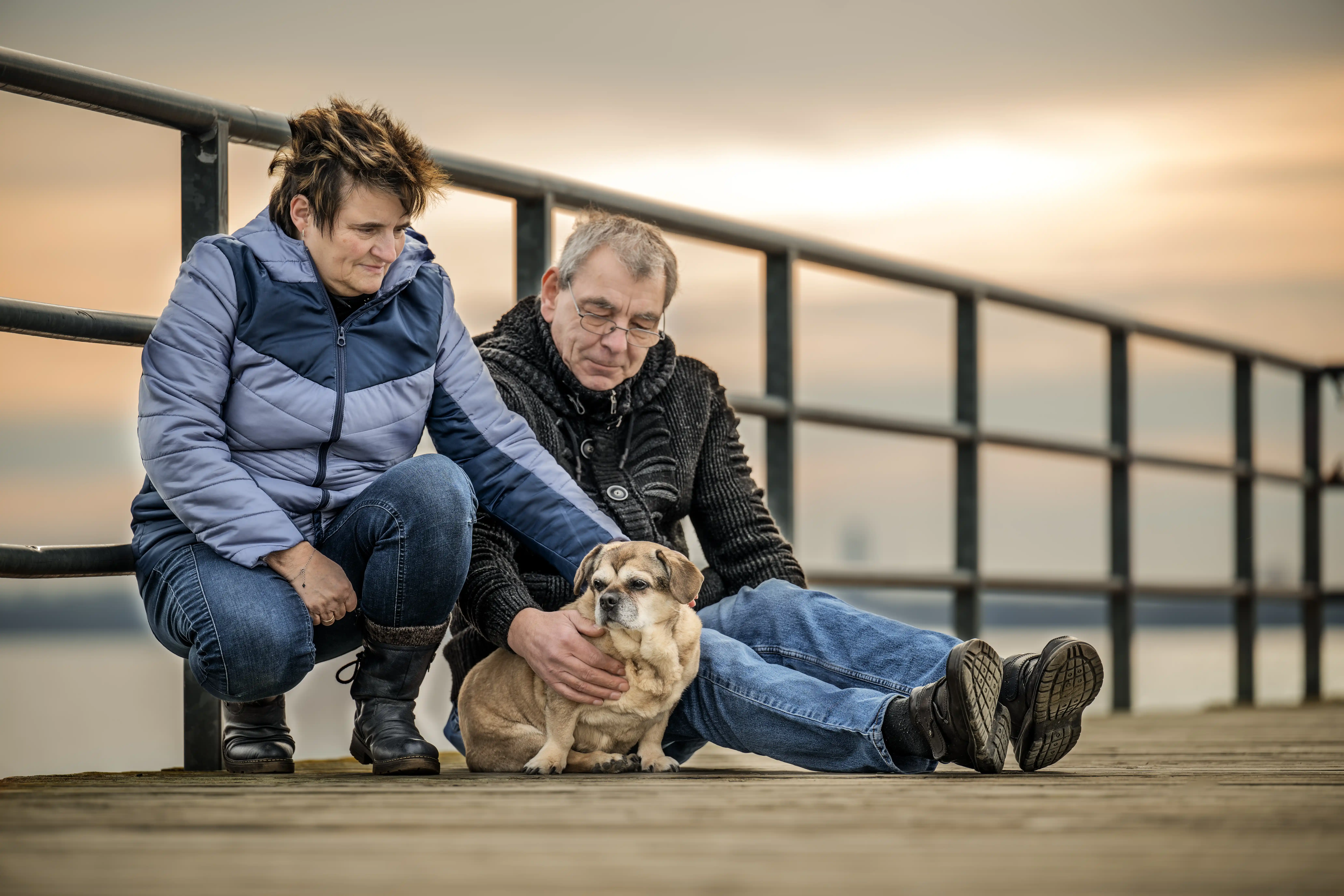 Zwei Menschen mit ihrer Hündin auf einem Steg
