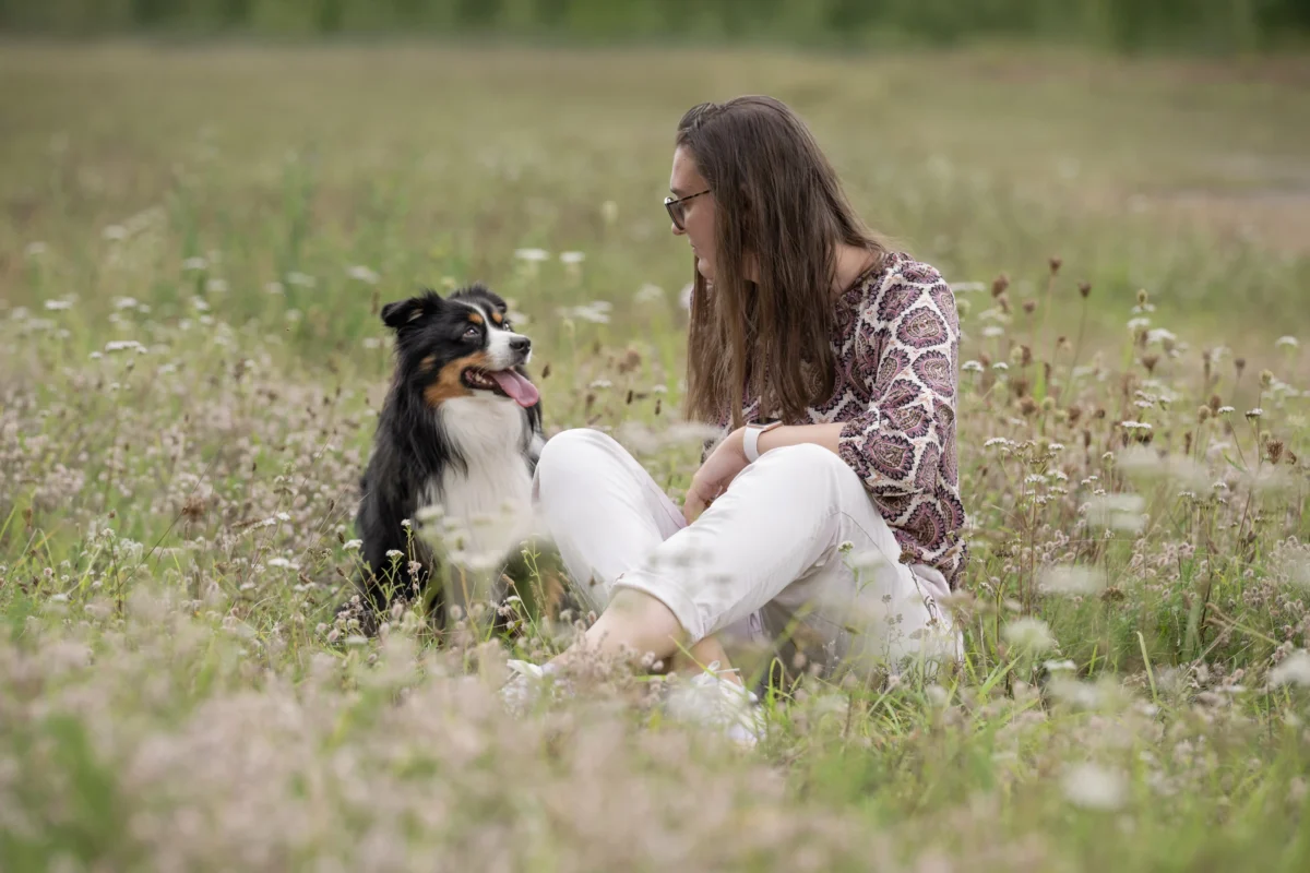 Eine junge Frau mit ihrem Mini Australian Shepherd